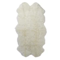 A Natural White Quad Sheepskin Rug with scalloped edges, a soft and plush texture, appears fluffy and rectangular. Photographed against a plain white background.