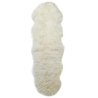 The Natural White Double Sheepskin Rug features a soft, thick texture and an irregular pelt shape with uneven edges, adding a cosy and plush touch to your home décor.