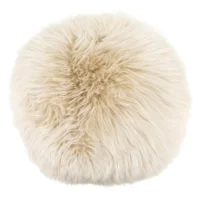 A round, fluffy, cream-coloured sheepskin cushion with long, shaggy fur. The soft and voluminous texture radiates evenly from the centre, giving this plush cushion a cosy and inviting appearance against a plain white background.