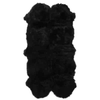 The Midnight Black Quad Sheepskin Rug features a long, plush, and fluffy texture. With its organic shape and rounded edges, it is thick, cosy, and ideal as a decorative floor piece or draped over furniture for added comfort.