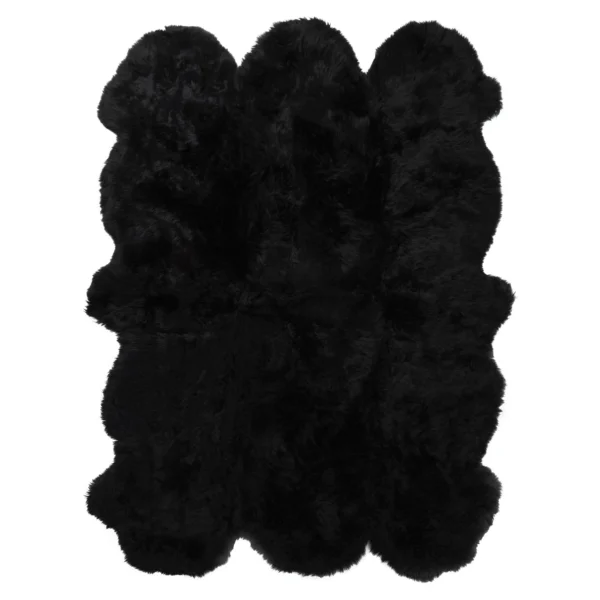 The Midnight Black 6 Pelt Sheepskin Rug is a fluffy, rectangular rug with a wavy, irregular edge and a thick, plush texture that reflects light for a subtle glossy appearance.