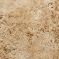 Close-up image of soft, light beige fibres with a wavy, fluffy, and slightly tangled texture. The plush surface appears dense, showing subtle variations in colour and direction, evoking warmth and cosiness. Includes sheepskin.