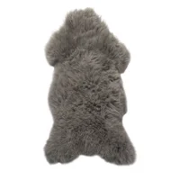 The Grey Sheepskin Rug features a soft, shaggy texture and thick, plush wool. Naturally shaped with rounded edges and uneven contours, it creates a cosy look when displayed on a white background.