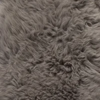 A close-up of dense, fluffy fibres with a soft, wavy texture and subtle grey variations, resembling the cosy plushness of the Grey British Sheepskin Rug.