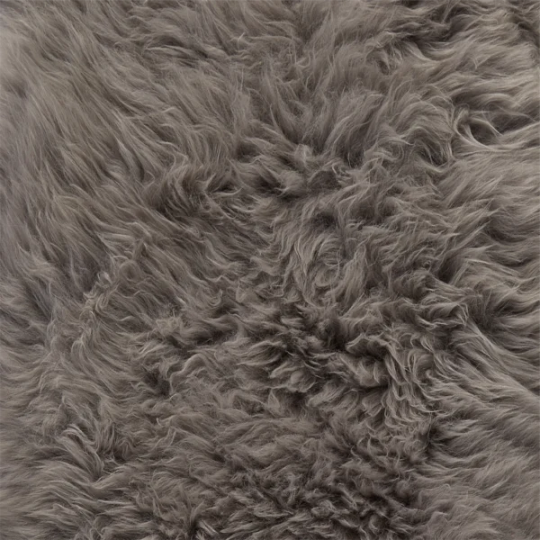 A close-up of dense, fluffy fibres with a soft, wavy texture and subtle grey variations, resembling the cosy plushness of the Grey British Sheepskin Rug.