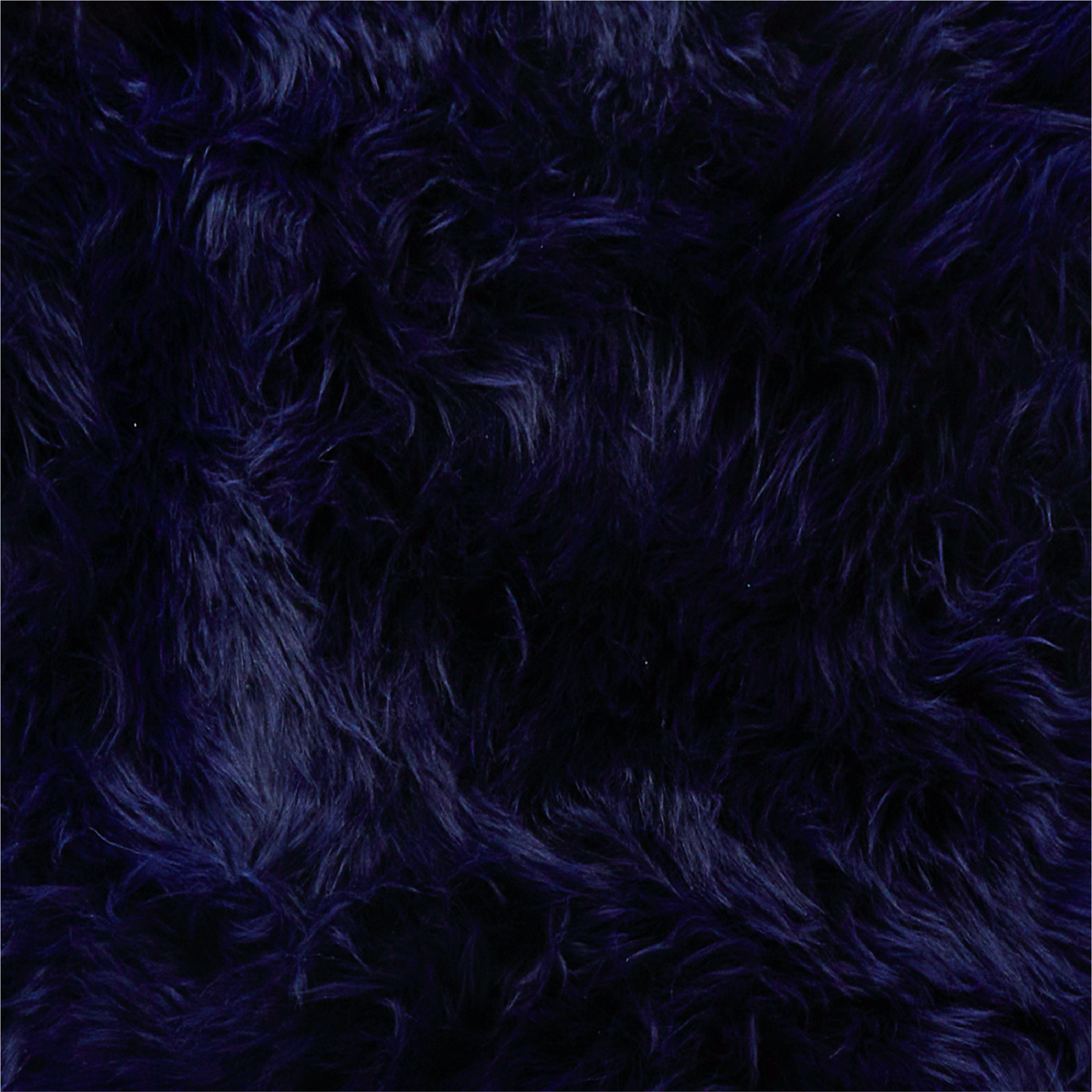 Close-up of dark blue, fluffy fibres with long, wavy strands creating a soft and dense texture. The material appears rich and plush, with subtle variations in shade due to the direction and length of the fibres. Sheepskin.