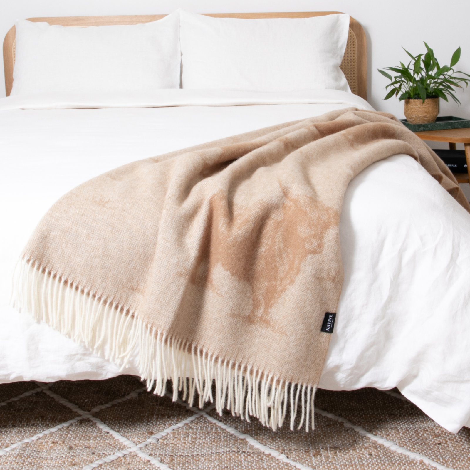 Bed styled with linen bedding and wool blankets